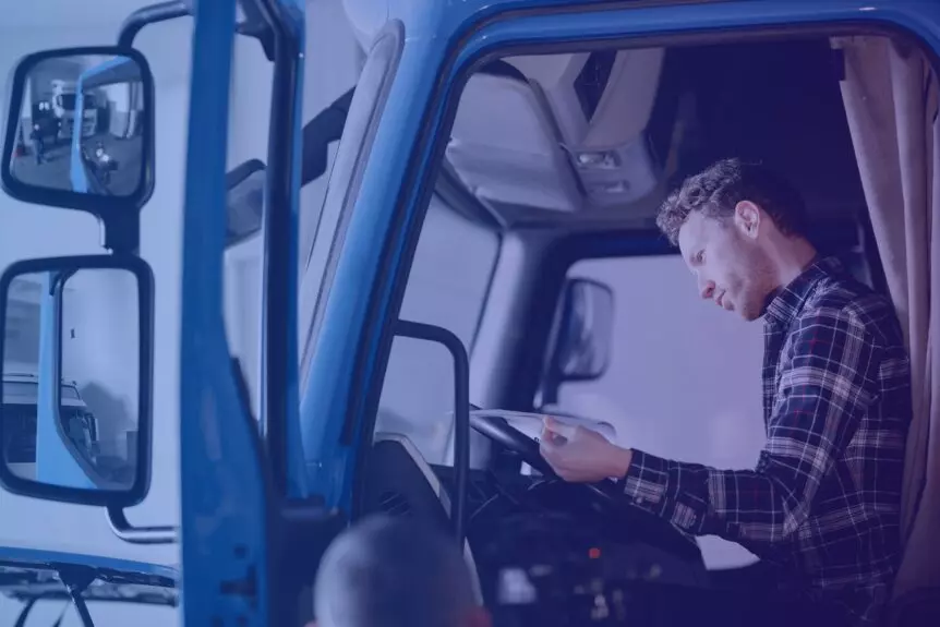 transportador autônomo na cabine de um caminhão conferindo um contrato de agregamento