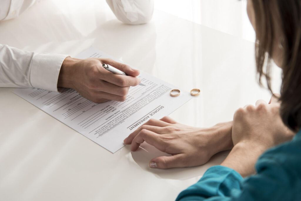 Casal assinando o acordo do divórcio onde consta o regime de bens do casamento ou de união estável